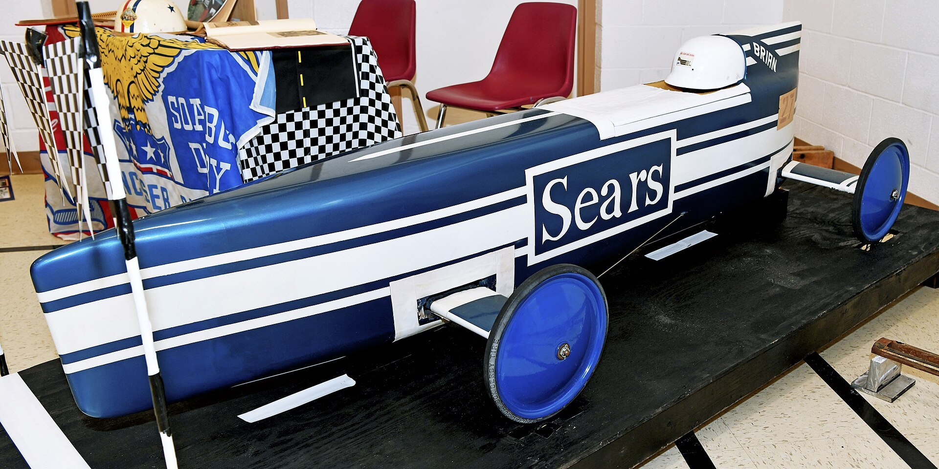 A 1974 Lancaster Ohio Soap Box Derby champion car displayed outdoors at a vintage derby car show with spectators nearby